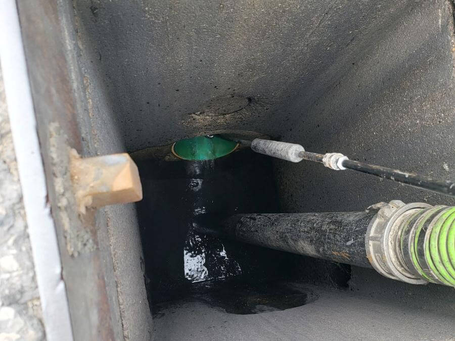 Catch basin being hydro flushed to clear a clog