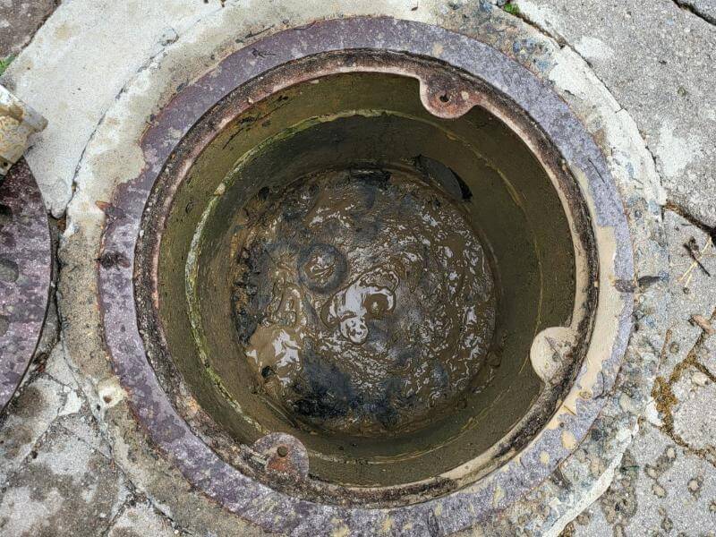 Clogged parking storm drain at a car dealership