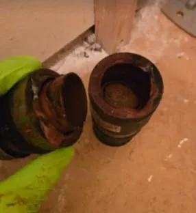 Corroded sump pump check valve showing mineral buildup and deterioration